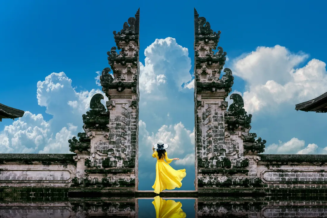 Woman standing temple gates lempuyang luhur temple in Bali, Indonesia